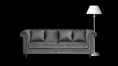 a velvet couch and a floor lamp