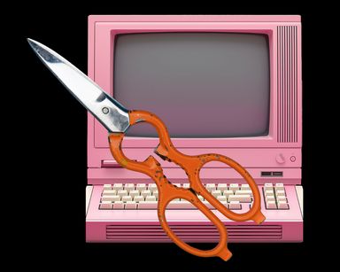 A scissor with a pink old-school computer in the background