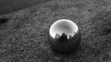 Photographer reflected in metal ball