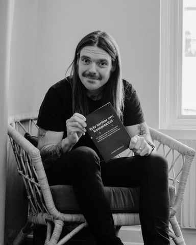 Anders Wengelin håller upp sin bok “Tolv tankar om komplexitet”.