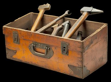 Rustic wooden toolbox filled with hammers and wrenches.